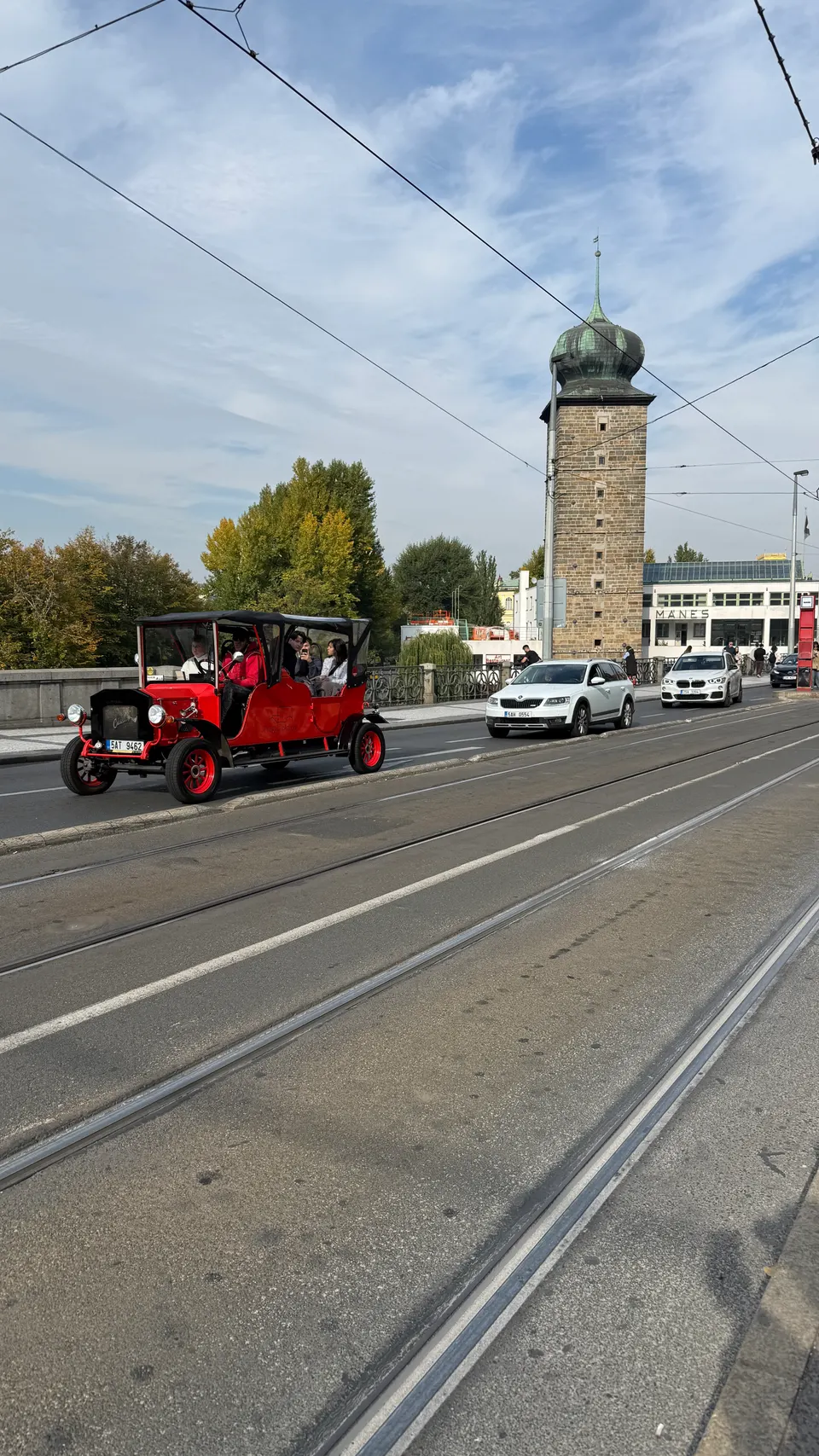 紅色老爺車開過，後面是 Šítkovská 水塔的綠色洋蔥頂。